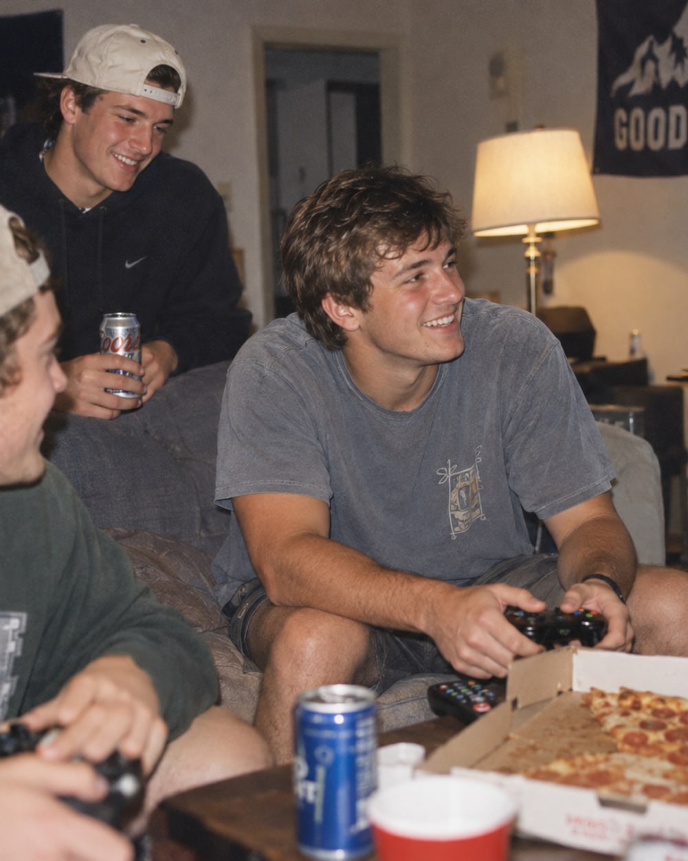 Couch, controllers, a pizza box, 2016: three guys laughing at each other, nobody at the camera